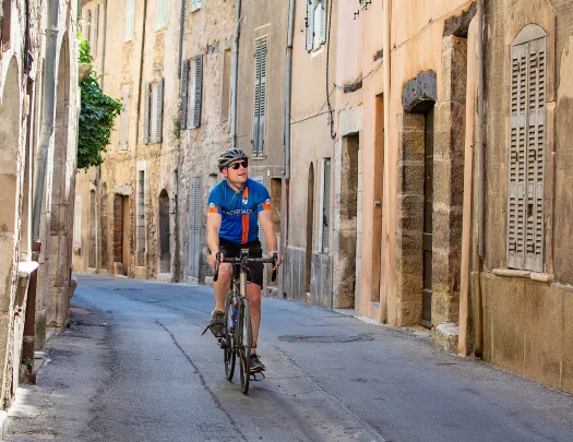 Biker riding riding through the old streets of a village in France