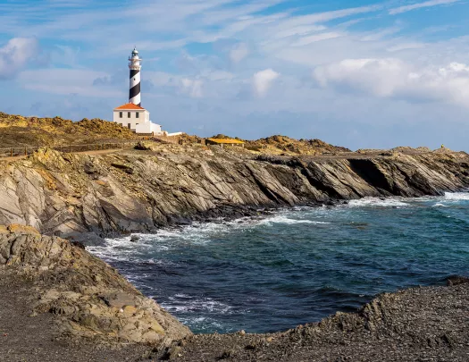 Rocky inlet, stripes lighthouse in distance.