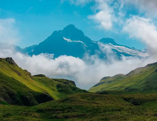 Valley view of Alpine mountains and clouds at the base.