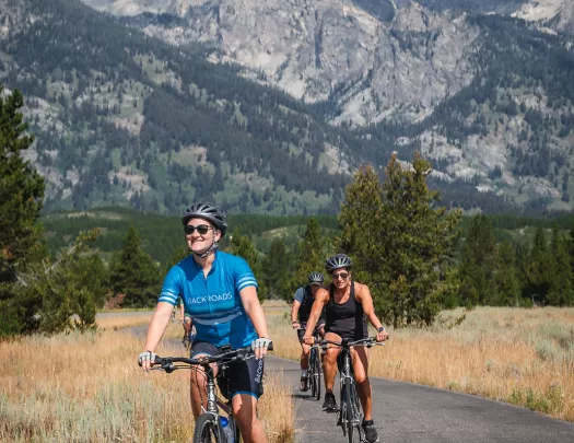 Backroads guests smiling while riding through mountain road