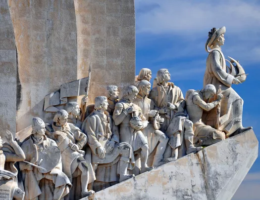 Close-up of intricate marble sculptures on building overhang.