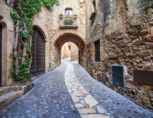 POV shot of stone alleyway, doors, windows, arches.