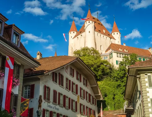 Ground-angle shot of Thun Castle, German architecture all around.