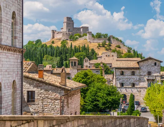 Wide shot of brick villages, large brick building on hilltop.