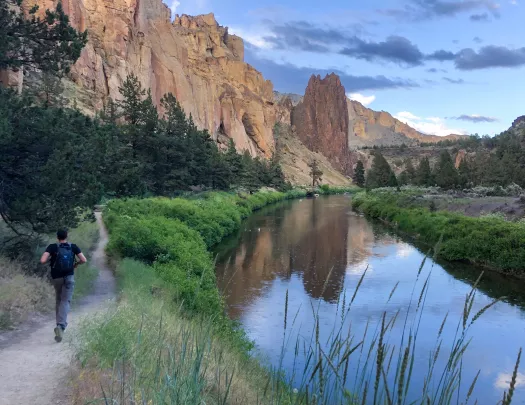 Guest running by small river in Smith Rock Park.
