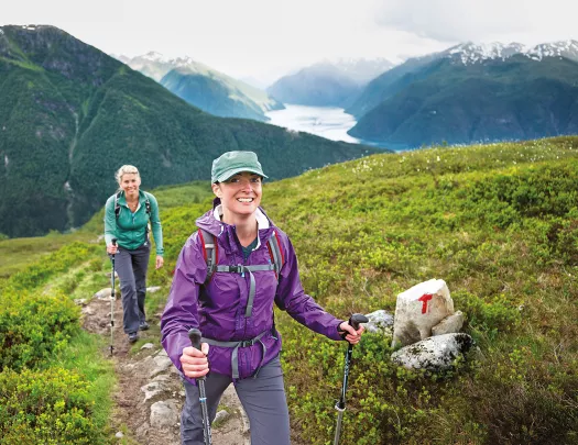 Two women hiking on a mountainous landscape.