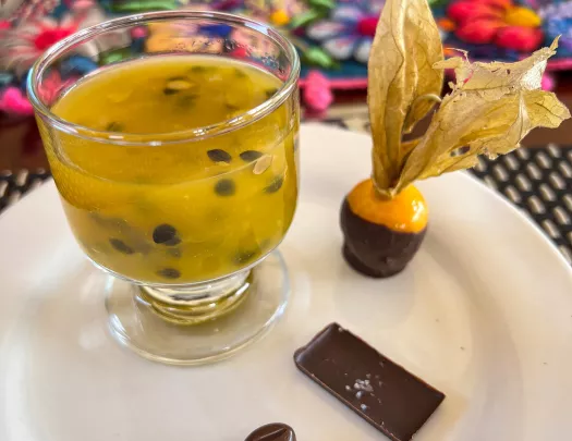 Fancy platter of seedy beverage and small chocolates.
