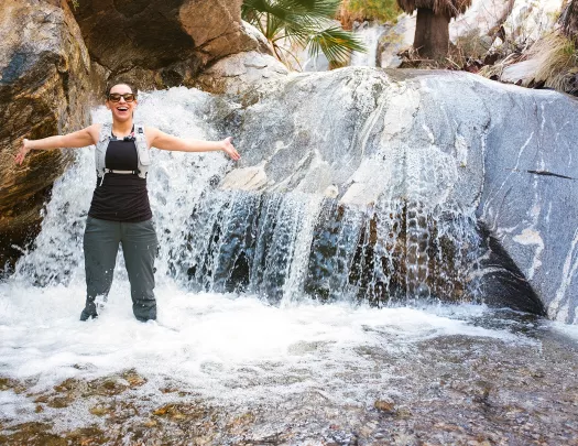 Woman with arms out in a waterfall