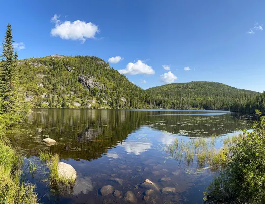 Wide shot of large lake, guest on left, looking out towards mountains.