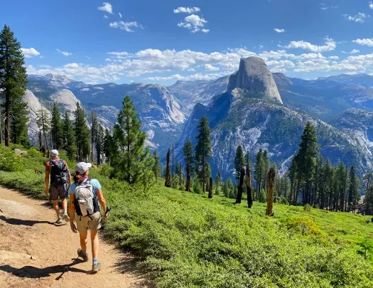 Guests hiking with Glacier Point in background.