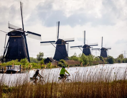 Two bikers in front of windmills