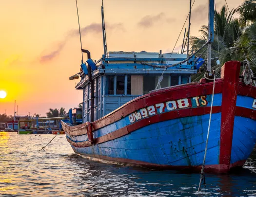 A boat in the water during sunset