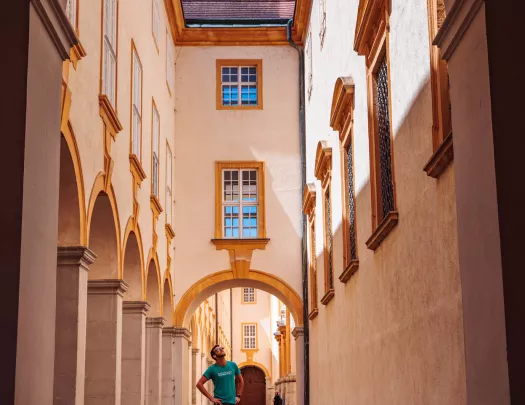 Man standing in an alleyway between two, rustic stone buildings