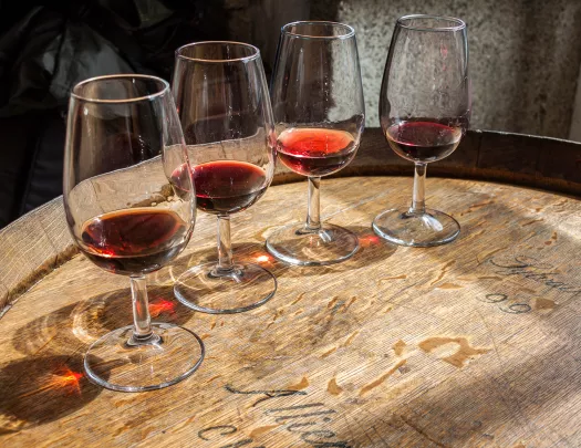 Four glasses of wine on top of a barrell