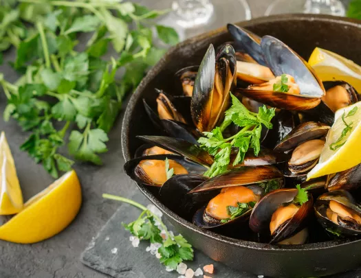 Bowel of cooked mussels with lemons and parsley