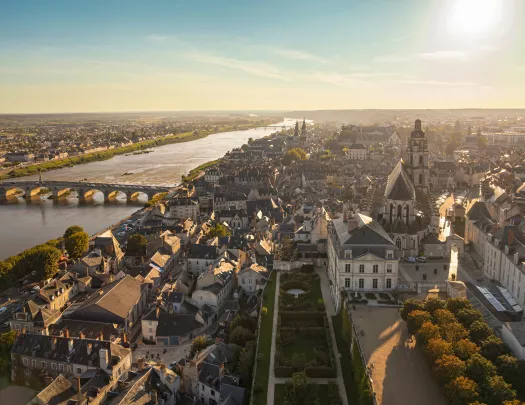 Sky view of a large, rustic town with a large bridge on the left