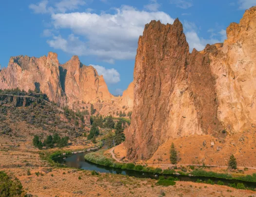 Large, orange canyons with a river on the ground level