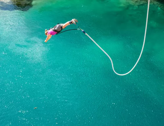 person bungee jumping into water