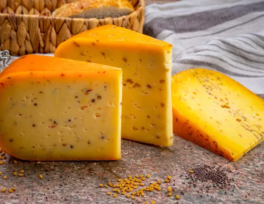 Three slices of cheese from a wheel on a stone slab