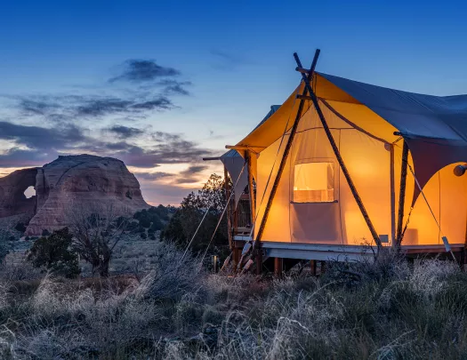 Glamping tent lit up in the desert