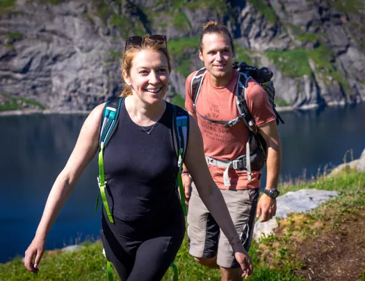 Man and women with backpacks ascending a mountain