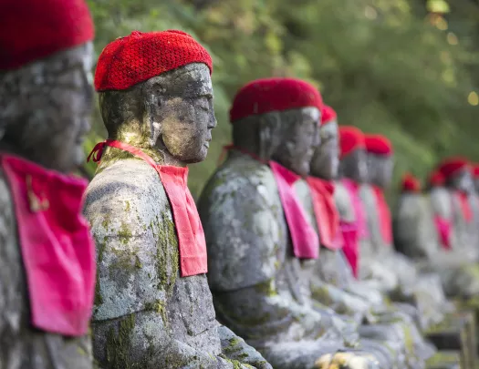 Row of stone statues, with knitted hats and handkerchiefs