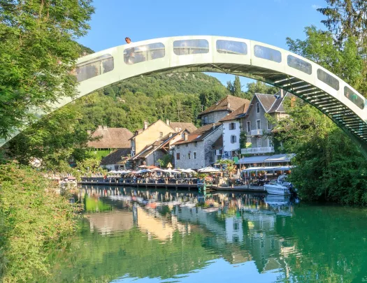 Large arch over a river, with a restaurant in the background
