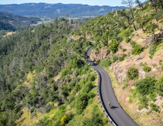 Person biking on an empty road on top of a hill