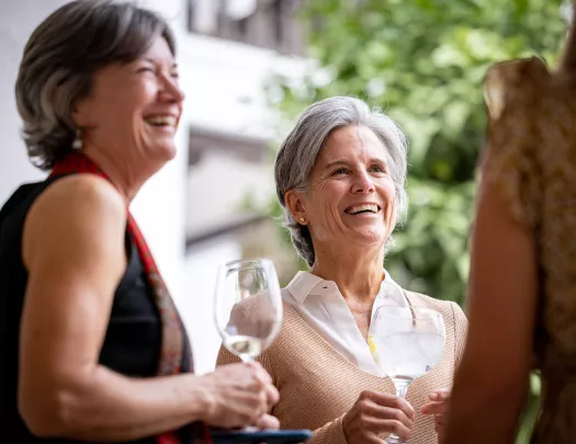 Group of women smiling while holding glasses of wine