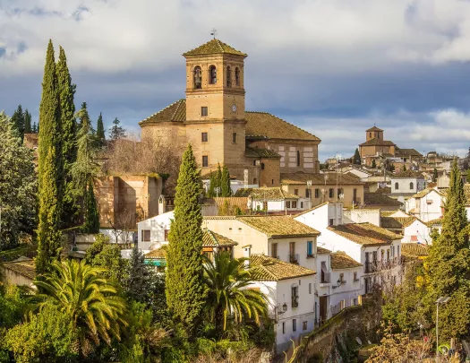 Rustic, white and yellow houses surrounded by tall trees