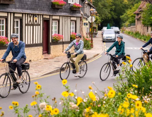 Group of people riding bikes on an empty road in a town