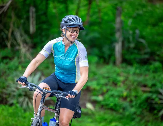 Woman wearing a Backroads jersey while riding a bike