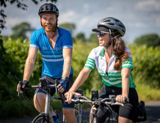 Man and woman riding bikes and smiling
