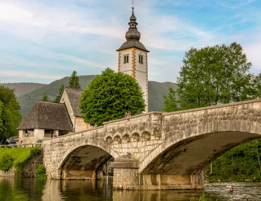 Large stone bridge with a bell tower in the background