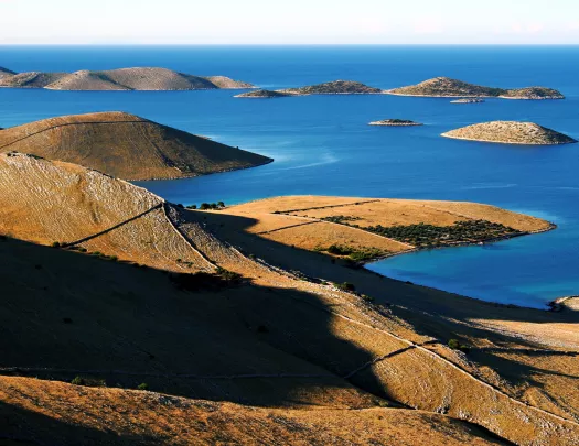 Large, dry hills with the ocean to the right