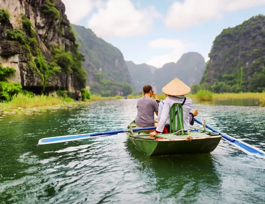 Group of people on a raft, paddling in the middle of a river