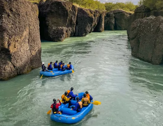Two blue rafts on a river full of groups of people