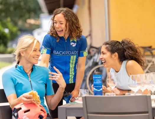 Three women smiling around a gray table