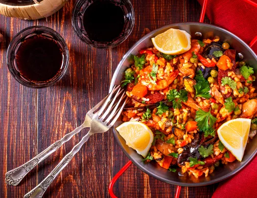 Bowl of paella with cut lemons on the sides