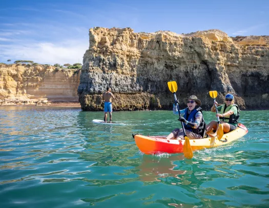 Two women laughing while paddling on a kayak