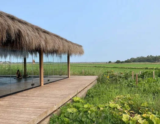 Room and hut with large windows, looking out to a large valley