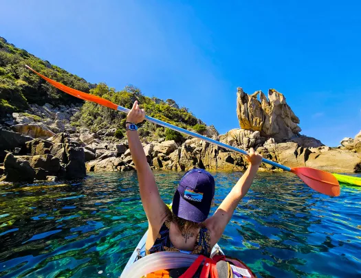 backroads guests holds up paddle while kayaking