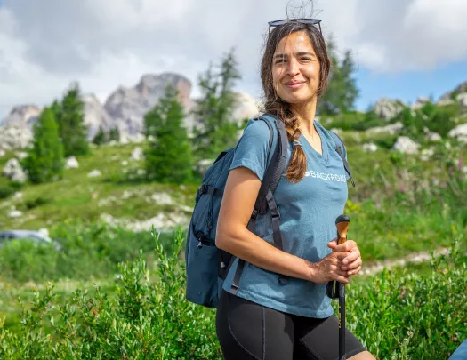 Woman smiling while standing in a grassy valley