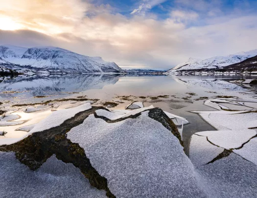 Large lake in the middle of a snowy valley with snow-capped mountains