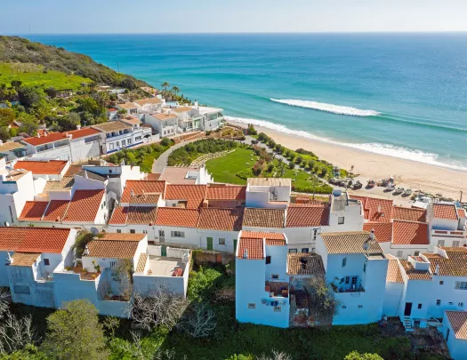 Sky view of white and brown houses next to the beach shore