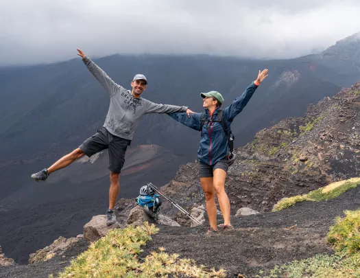 Two backroads guest pose with their hands up on a hike