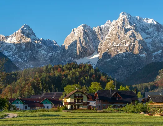 Exterior view of hotel complex buildings in a valley, with large mountains in the distance