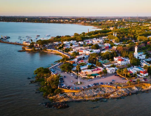 Sky view of small town by the ocean, with cars parked along the beach