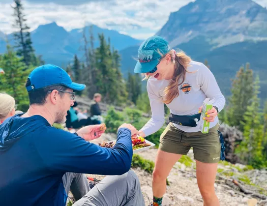 Woman passing a plate of snacks to a man