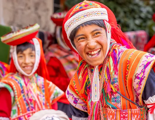Boy in traditional attire, smiling with a group of other boys behind him